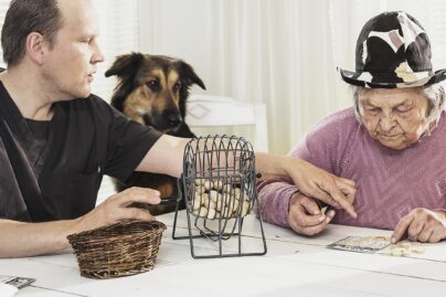 Mummu ja hoitaja pelaavat bingoa yhdessä.