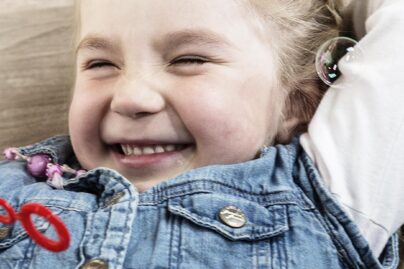 hymyilevä tyttö puhaltaa saippuakuplia