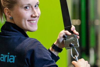 Coronarian naisfysioterapeutti hymyilee työskennellessään.