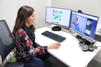 Etäpuheterapeuttina toimiva Maria Herva työskentelemässä tietokoneella.