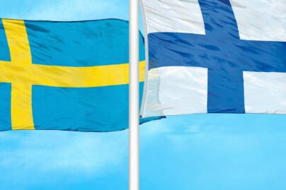 ruotsin ja suomen lippu liehuvat tangoissa ulkona