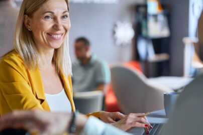 keski ikainen nainen hymyilee konttorilla