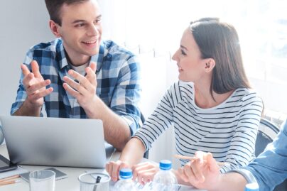 tyoryhma miehia ja naisia keskustelemassa toimistolla poydan aaressa