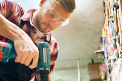 mies tekee puutoita suojalasit paassa