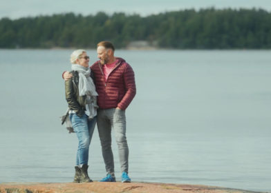 mies ja nainen seisovat ulkona rantakalliolla