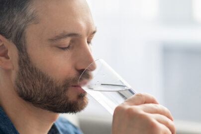 keski-ikäinen mies juo vettä juomalasista