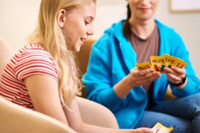 Tyttö ja toimintaterapeutti pelaavat Aliasta työharjoittelussa