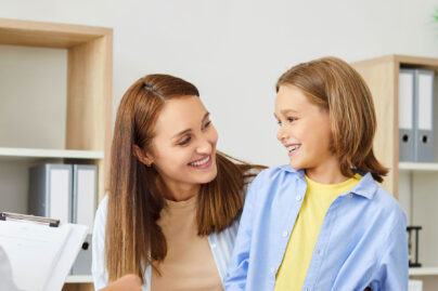 Lääkärin B lausunto lääkärin vastaanotolla äiti ja lapsi hymyilevät