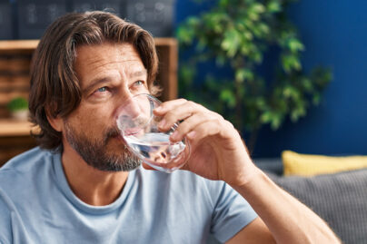 Mies juo lasista vettä