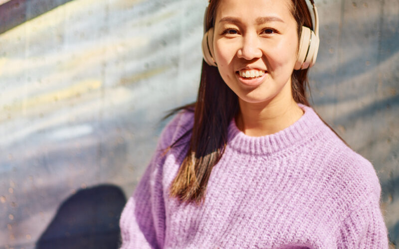 Nuori nainen kuulokkeet päässä.