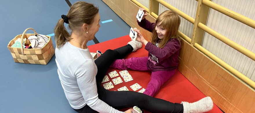 Fysioterapeutti ja lapsi istuvat jumppamatolla ja tekevät harjoitusta