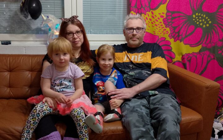 Aurora istuu kotinsa sohvalla koko perheen kanssa.