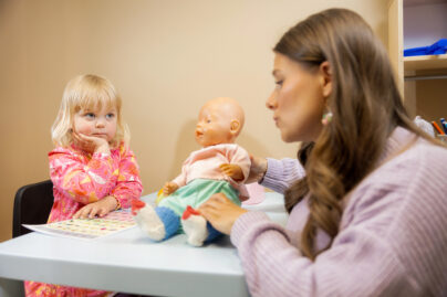 Lapsi harjoittelee ydinsanoja kuvatuen avulla puheterapeutin ohjauksessa.