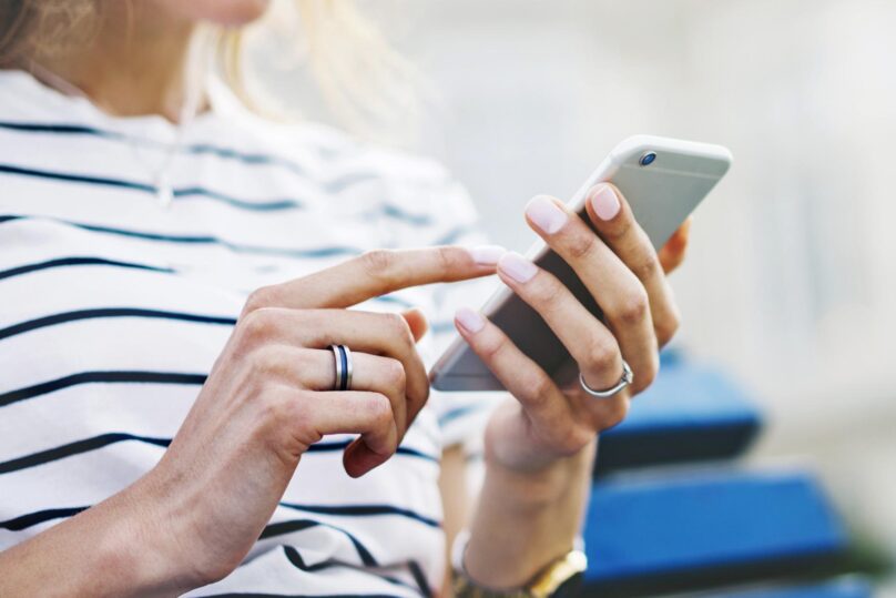 Lähikuva naisen käsistä käyttämässä älypuhelinta.