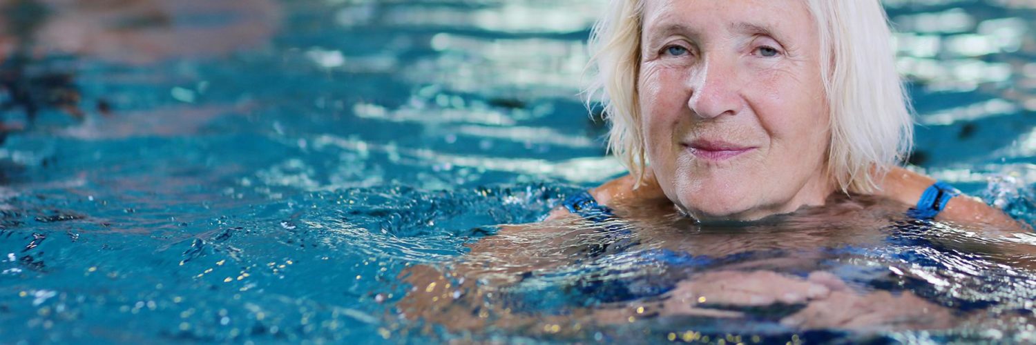 Seniorinainen uimassa uimahallissa