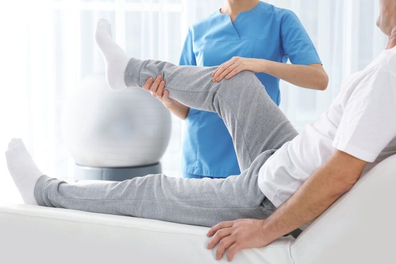 fysioterapeutti-tutkii-mies-asiakaan-jalkaa