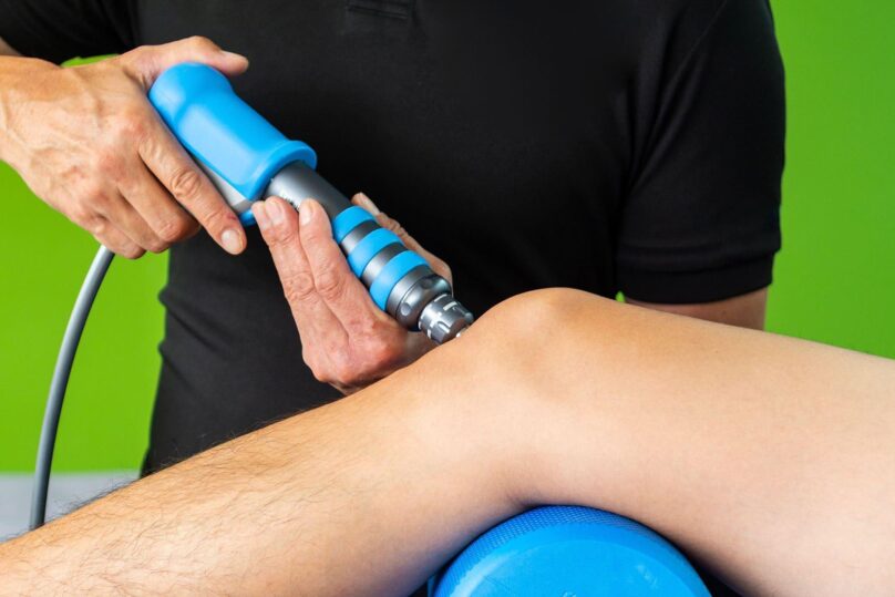 fysioterapeutti antaa asiakkaan polveen shockwave terapiaa