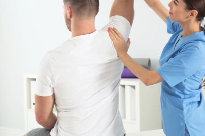 naisfysioterapeutti tutkii miesasiakkaan selkaa