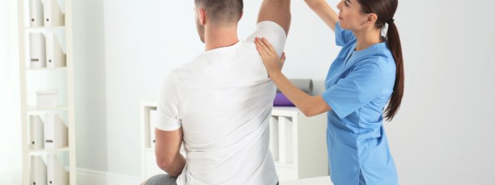naisfysioterapeutti tutkii miesasiakkaan selkaa