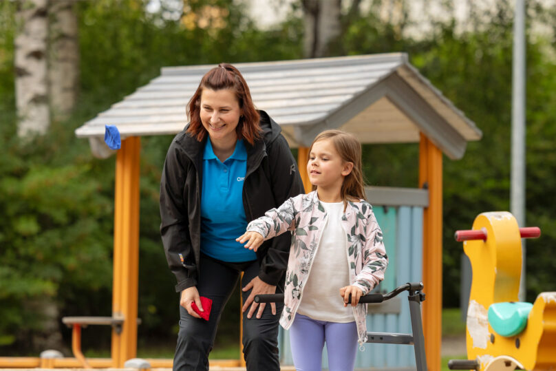 Neurologisen fysioterapian naisterapeutti ja lapsiasiakas tekevät leippuistossa harjoitusta hernepussien avulla.