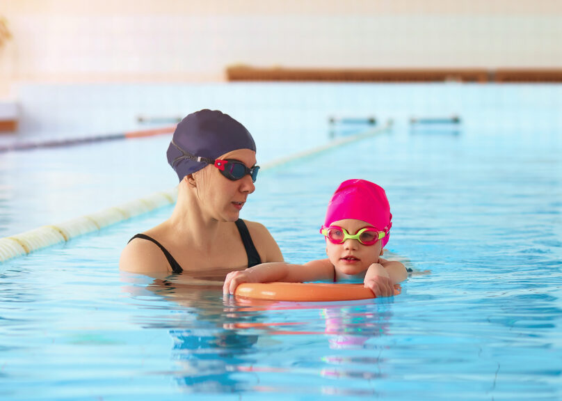 Nainen ja lapsi uima-altaassa tekemässä harjoitusta