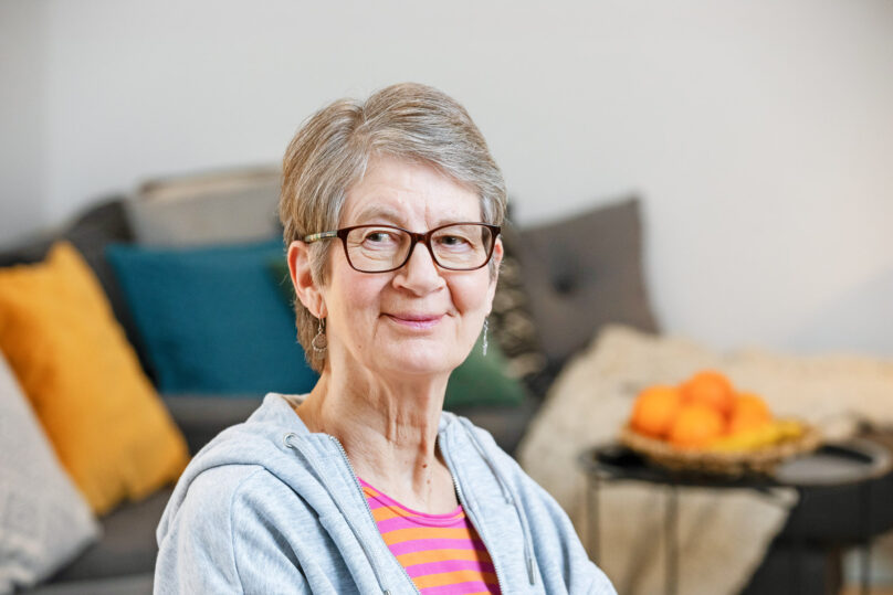 Seniorinainen lähikuvassa katsoo vinosti kohti.