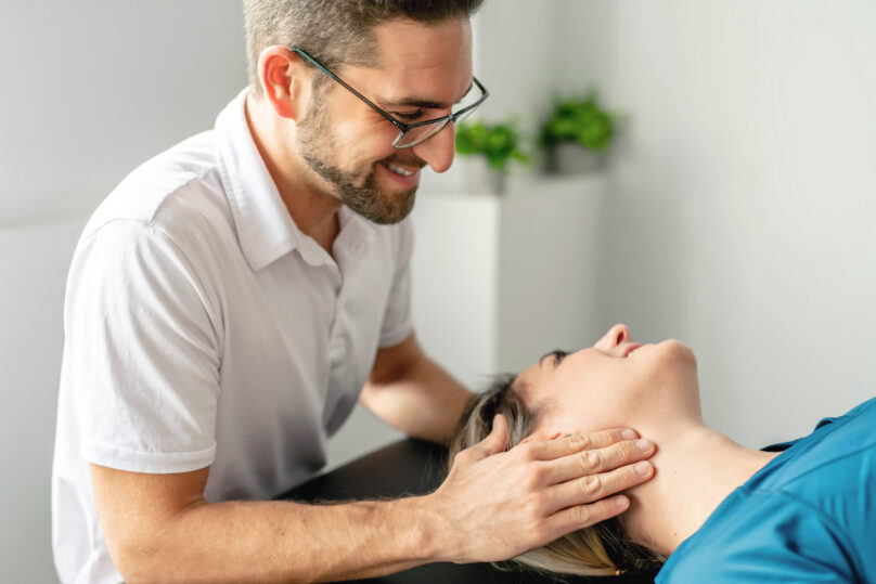 Miesterapeutti käsittelee naisasiakkaan kaulaa