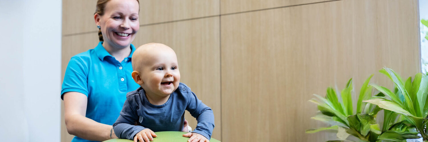 fysioterapeutti vauvan kanssa jumppapallon päällä