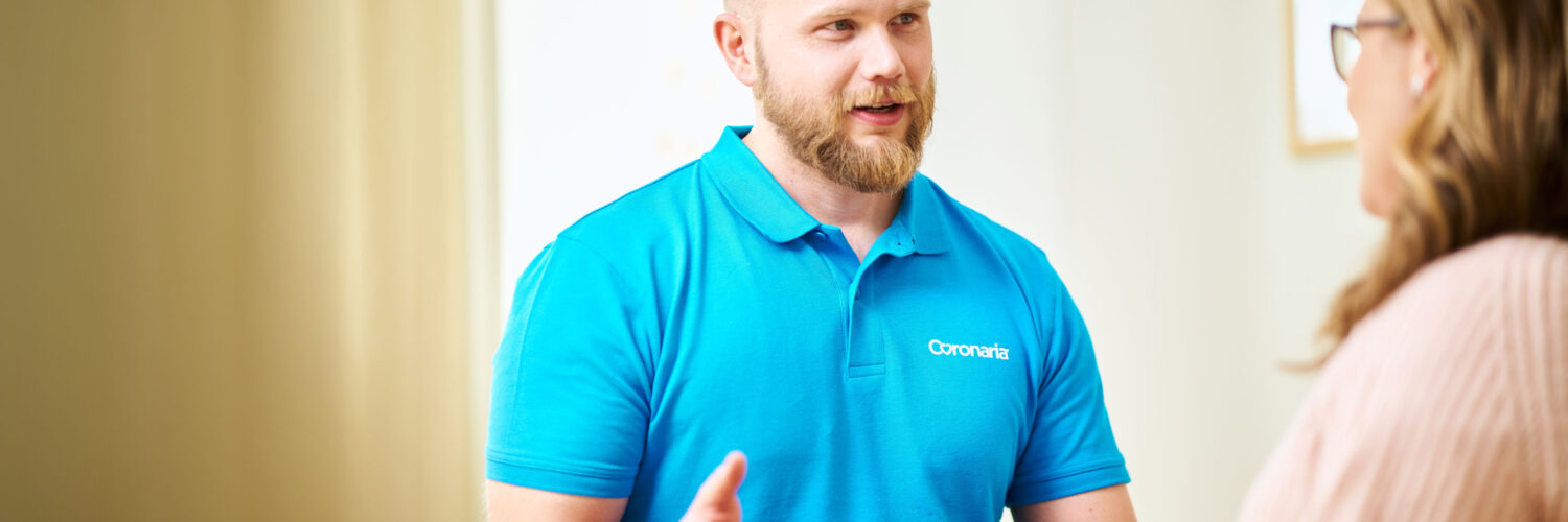 Fysioterapeutti keskustelee naisen kanssa.