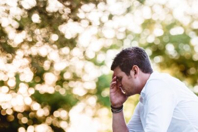 Mies miettii käsi kasvojen päällä