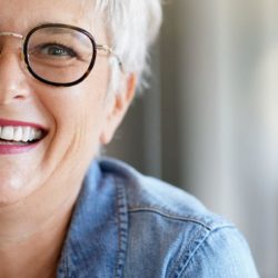 nainen hymyilee silmalasit paassa