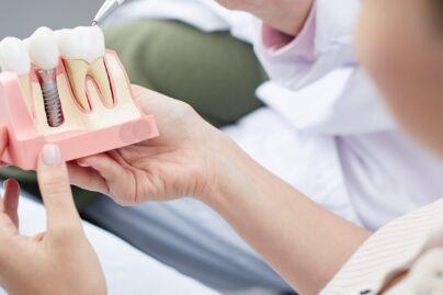 Naishammaslääkäri katselee hammasproteesin mallia