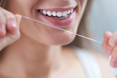 nainen kayttamassa hammaslankaa