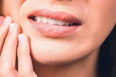 nainen pitaa kiinni leuasta suun vieresta