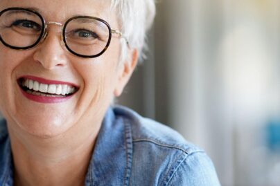 nainen hymyilee silmalasit paassa