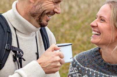 Nainen ja mies ovat ulkoilemassa ja katsovat toisiaan hymyillen.