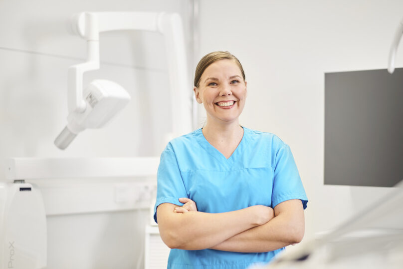 suuhygienisti hymyilee hammasklinikalla.