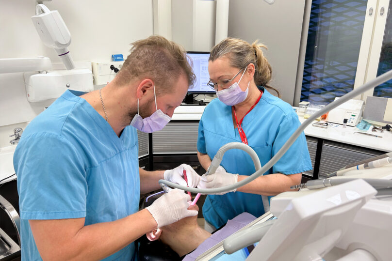 Hammaslääkäri valmistelee potilasta kalvo-oikomista varten kiinnittämällä hampaisiin pieniä hampaan värisiä muovikiinnikkeitä, jotta kalvot pysyvät hyvin paikallaan.