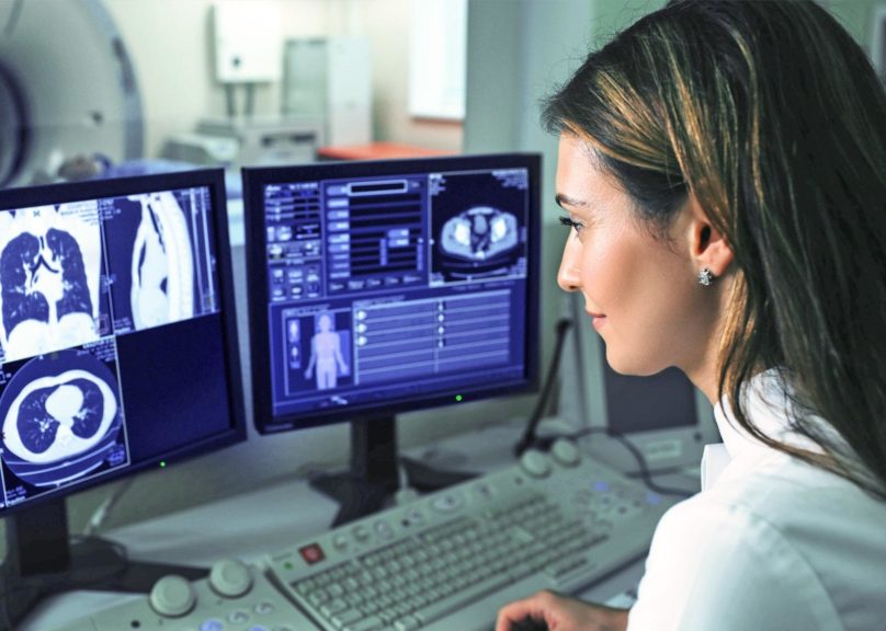 Naislääkäri katsoo ruudulta CT scan tuloksia.