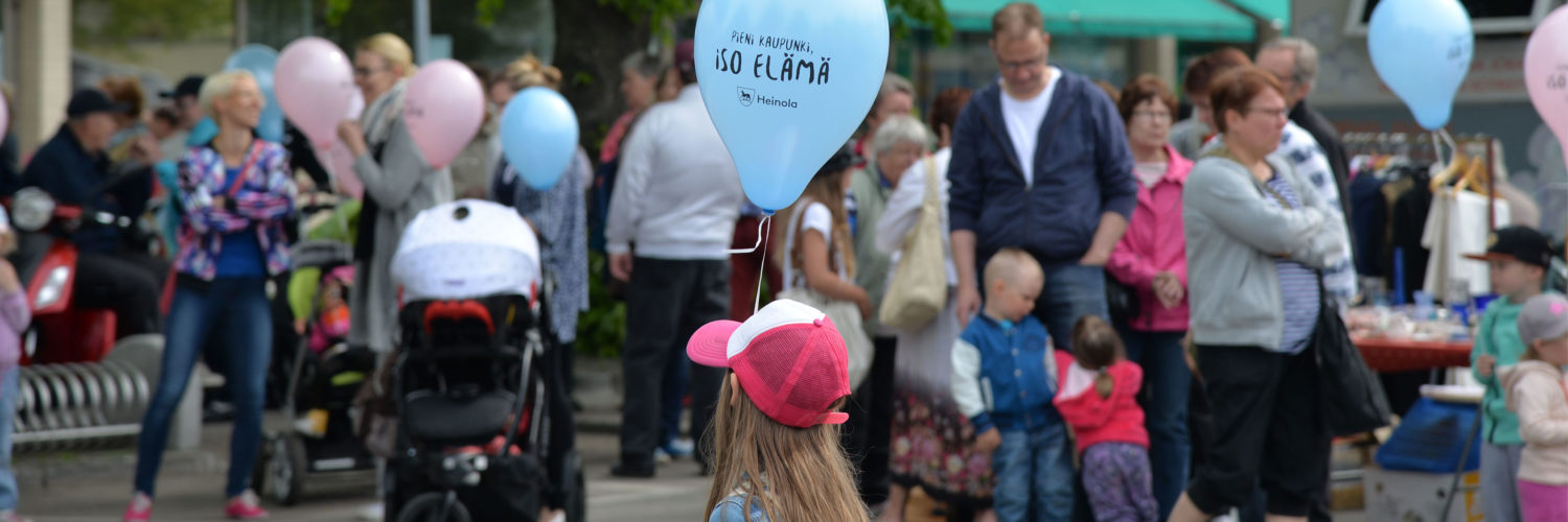 Tyttö pitelee ilmapalloa keskellä ihmisvilinää Heinolan kaupungin tapahtumassa