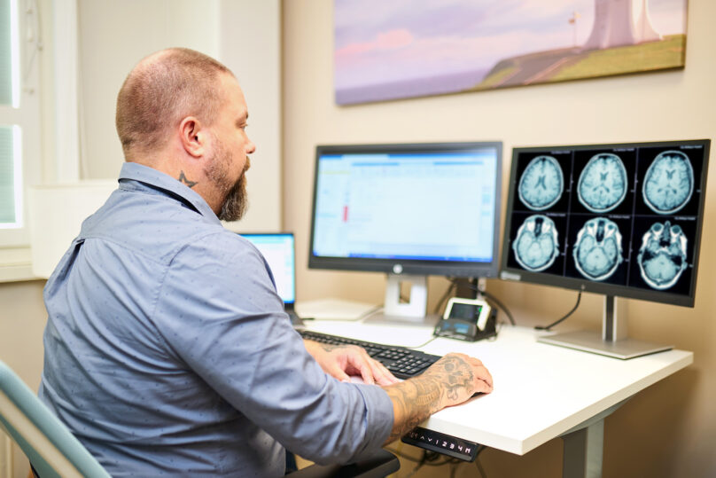 Radiologi työskentelee tietokoneella.