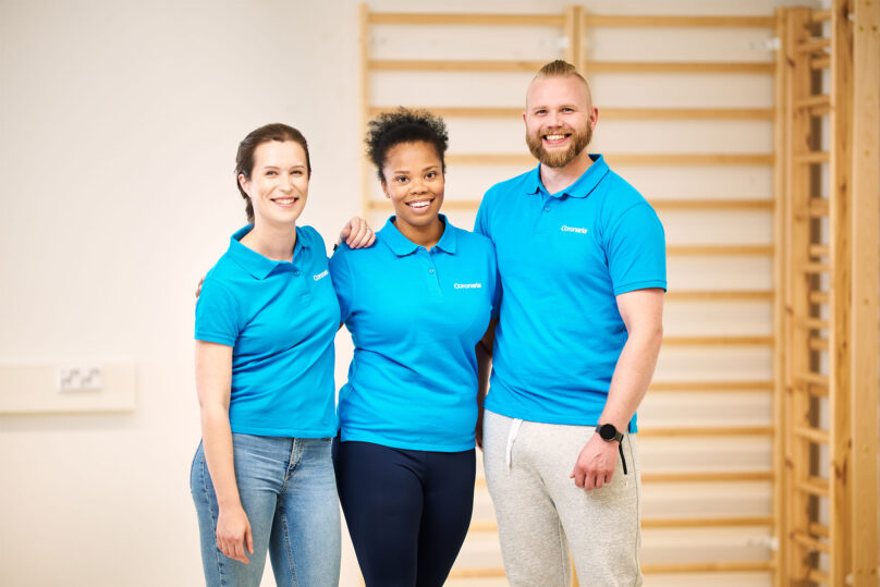 coronarian ammattilaiset hymyilevat rivissa ja katsovat kameraan