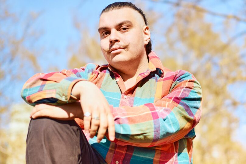 Kuvassa nuori mies miettii, että nuoren mielenterveys voi joskus olla koetuksella, kun elämä kuormittaa opiskelujen ja töiden vuoksi.