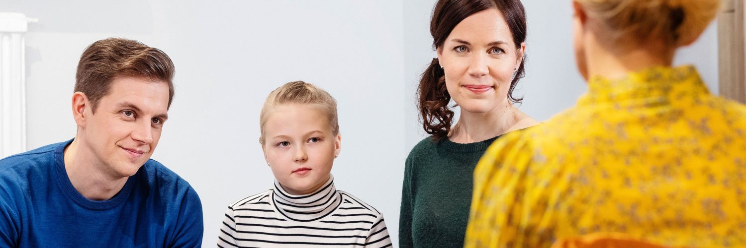 perhe keskustelemassa terapeutin kanssa