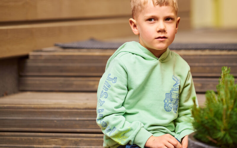 Poika istuu portailla Coronaria sopeutumisvalmennus lasten kielihäiriö