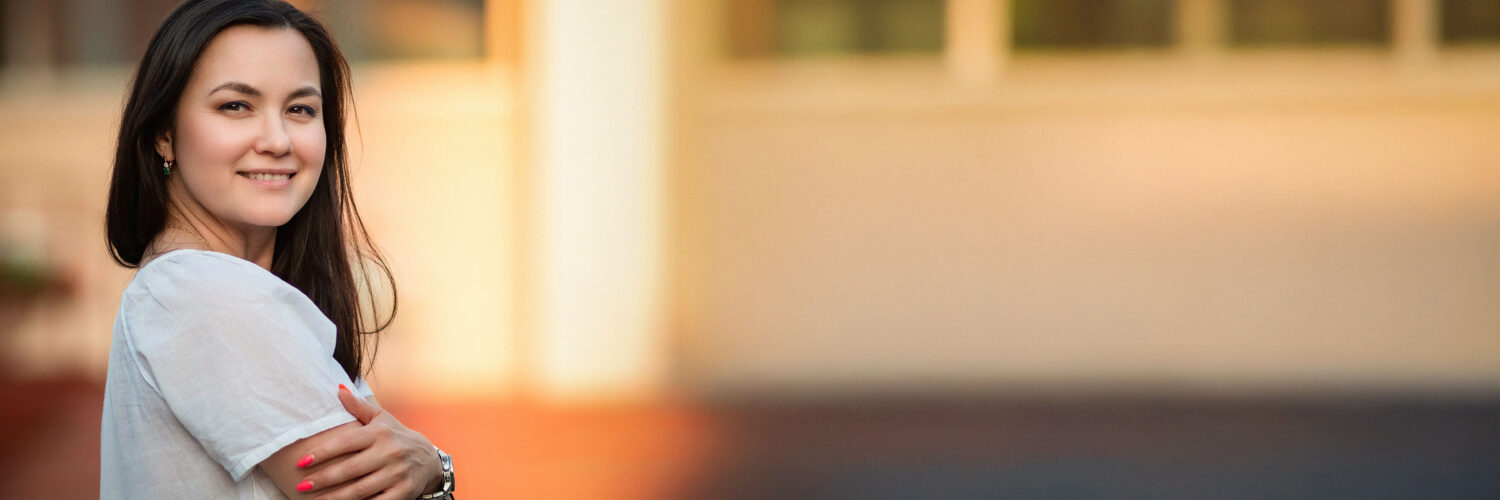 nainen hymyilee ulkona saamenkielisten mielenterveyskuntoutus