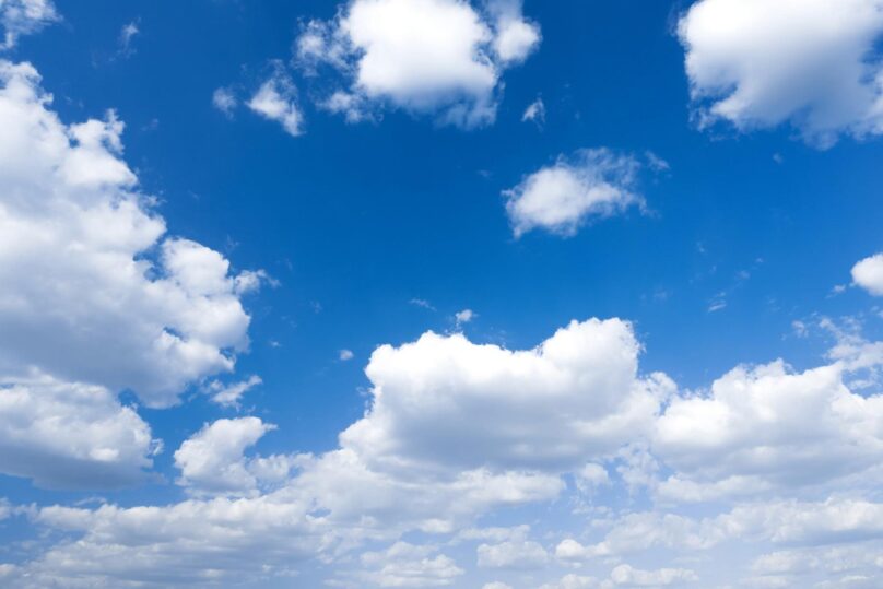 Sininen taivas ja valkoisia kumpupilviä.