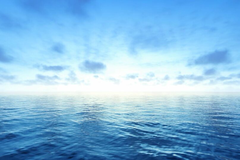 Kirkkaan sininen vesistö ja taivas, jossa hieman tummia pilviä.