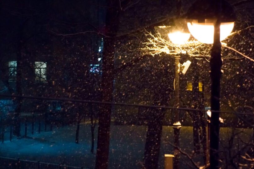 Tumma yö kaupungissa ja katuvaloissa kirkkaat valot.