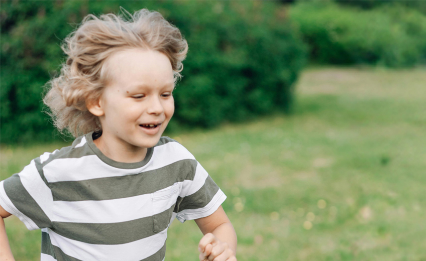 coronaria laku perhekuntoutus poika juoksee ulkona nurmikolla
